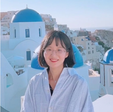 A person smiling in front of a white buildingAI-generated content may be incorrect.